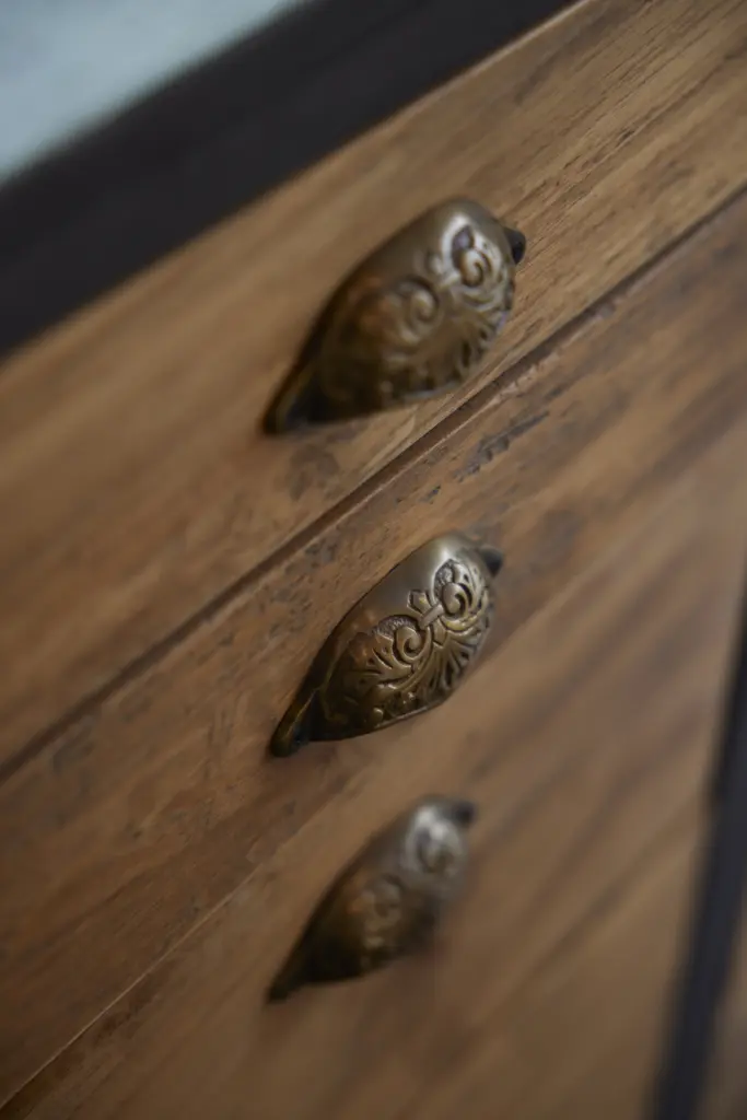 無垢材の引き出しに取り付けられた、アンティーク調の装飾が美しい金属製の取っ手。アンティクのモデルハウスの造作キッチンにおける、こだわりのディテール