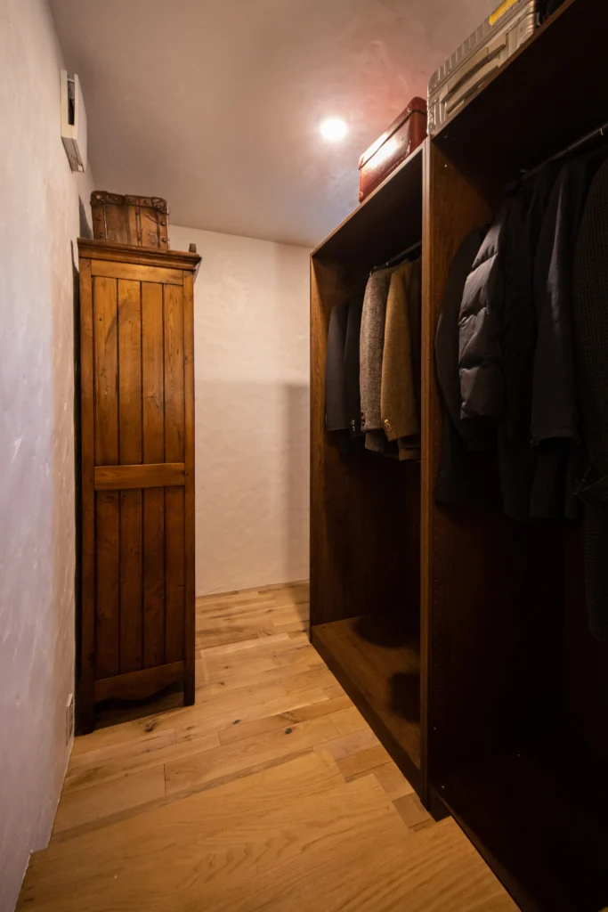 無垢材の床と漆喰調の壁に、アンティーク家具とオープン棚が馴染むウォークインクローゼット